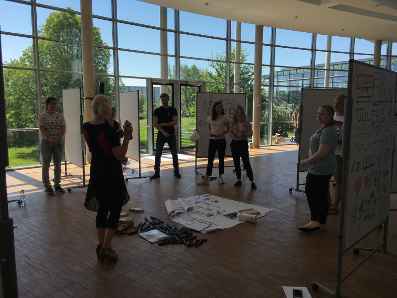 People stand in a circle and talk about individual posters